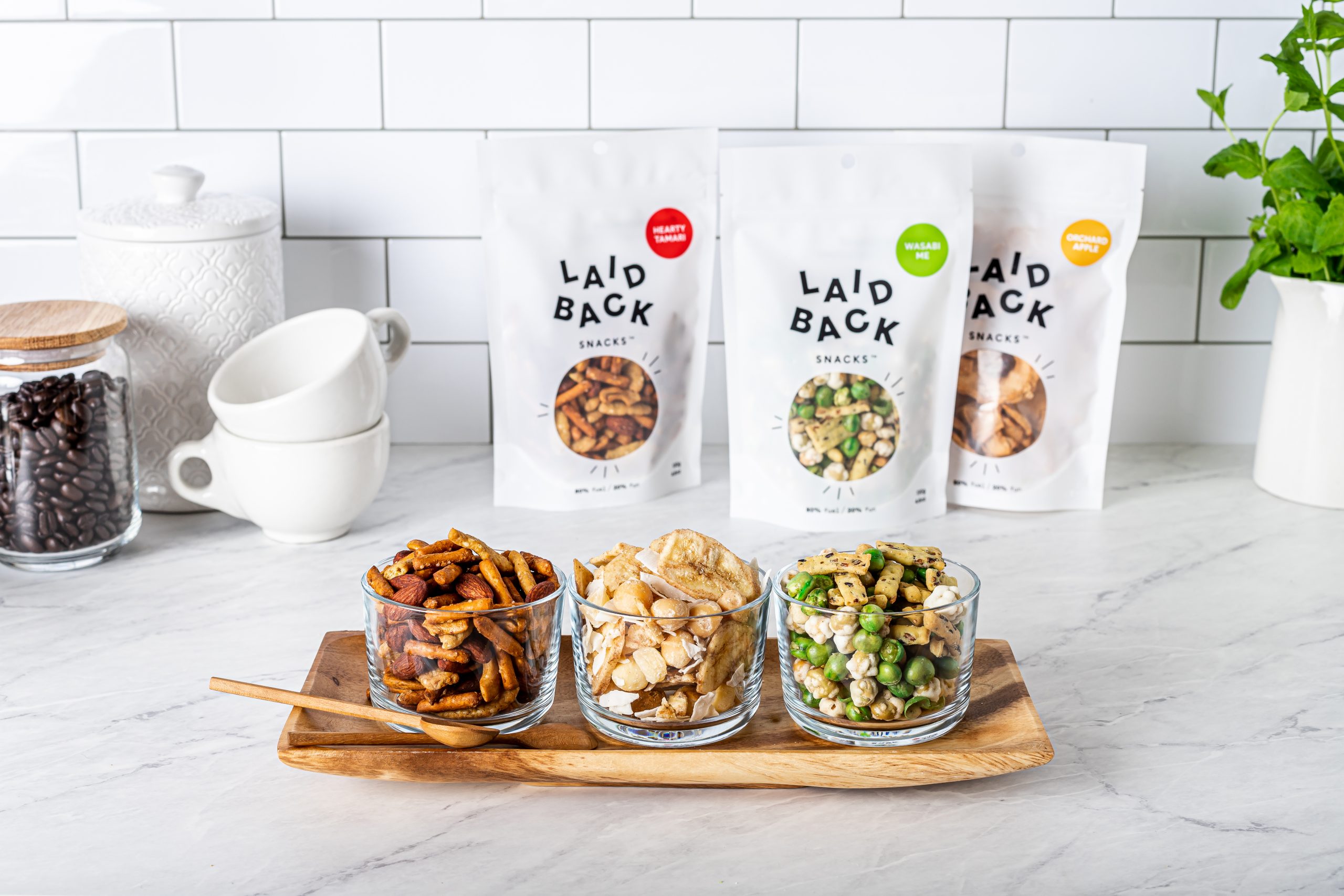 A three bowls of snacks on a marble kitchen countertop.